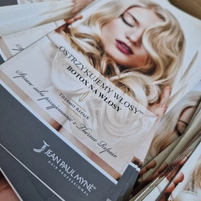 Ulotki promujące botox na włosy, na ich okładce piękna pani z ładnie ułożonymi włosami